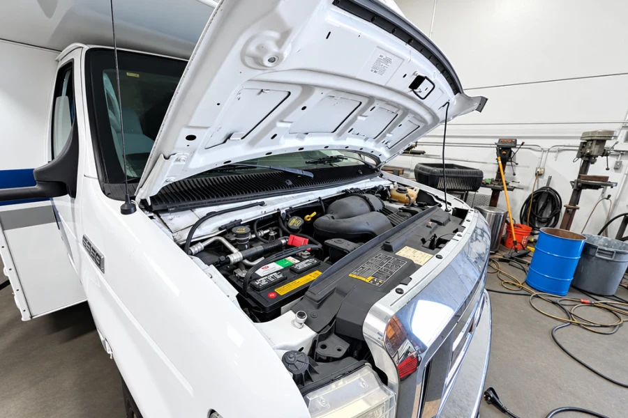 Class C motorhome with the hood open for routine engine maintenance