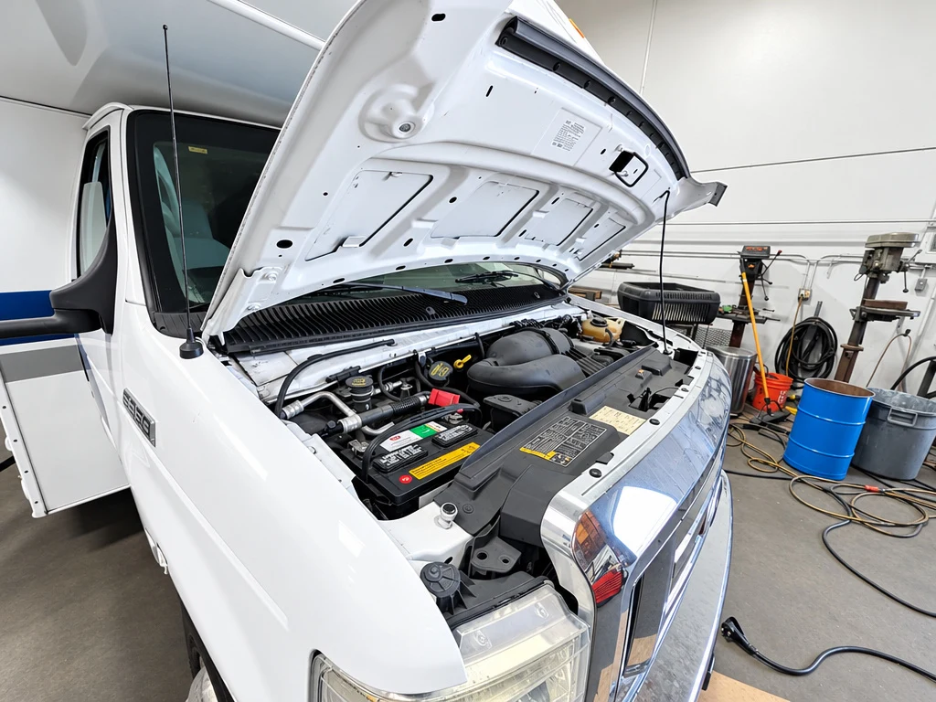 Class C motorhome with the hood open for routine engine maintenance