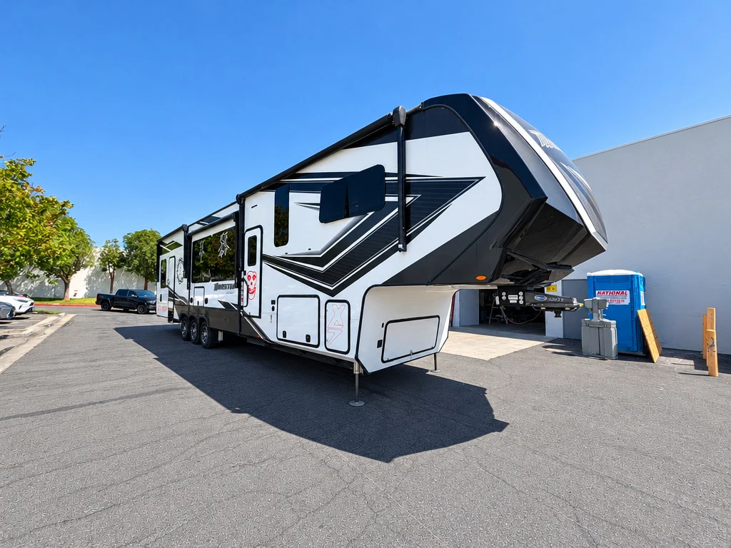 Black and white fifth wheel trailer outside El Toro RV Service in Orange, CA