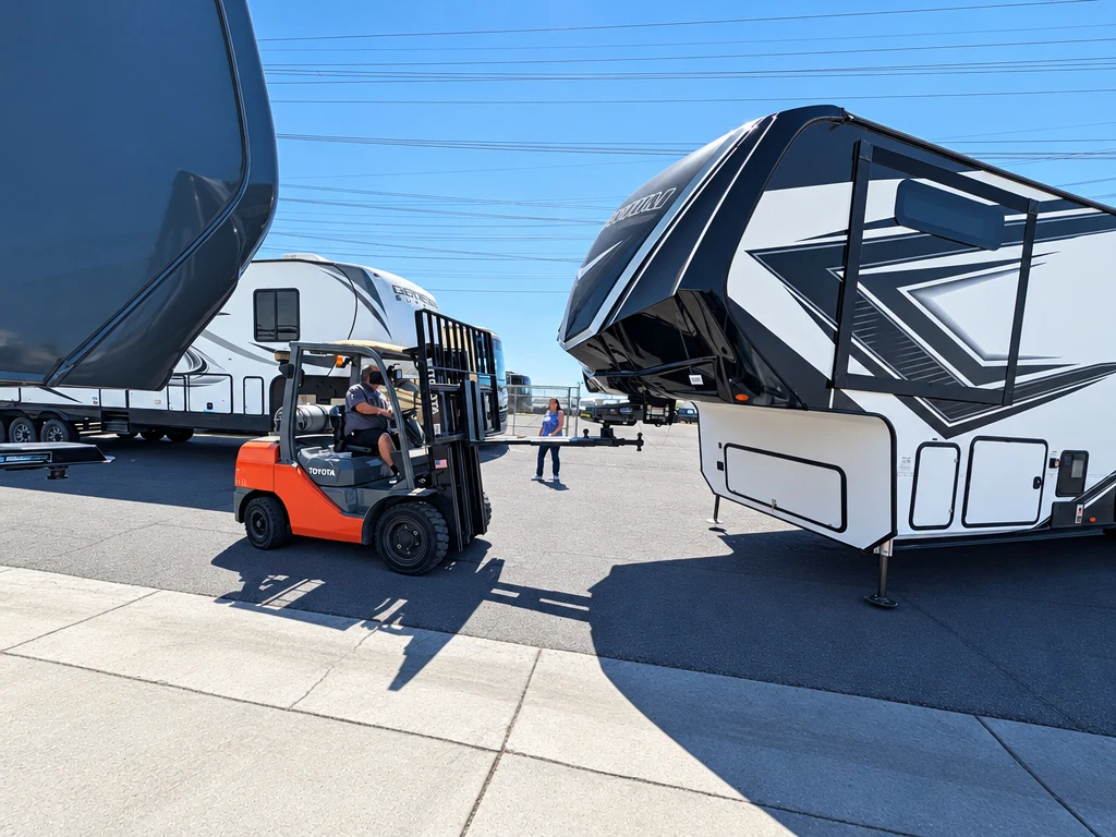 Forklift moving a fifth wheel trailer outside El Toro RV Service