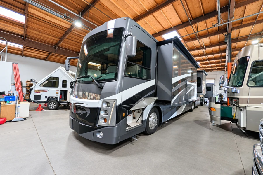 Front cap and graphics of a gray Class A motorhome in the El Toro shop