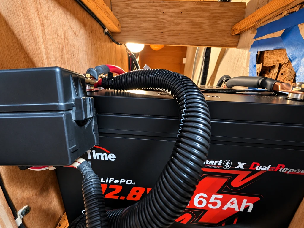 12.8V LiFePO4 lithium battery being installed in an RV
