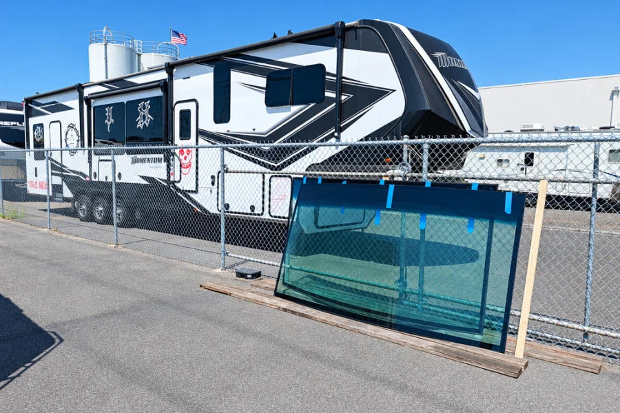 New replacement windshield glass on a stand outside El Toro RV Service
