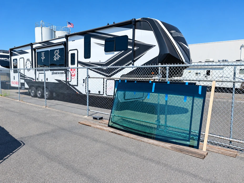 New replacement windshield glass on a stand outside El Toro RV Service