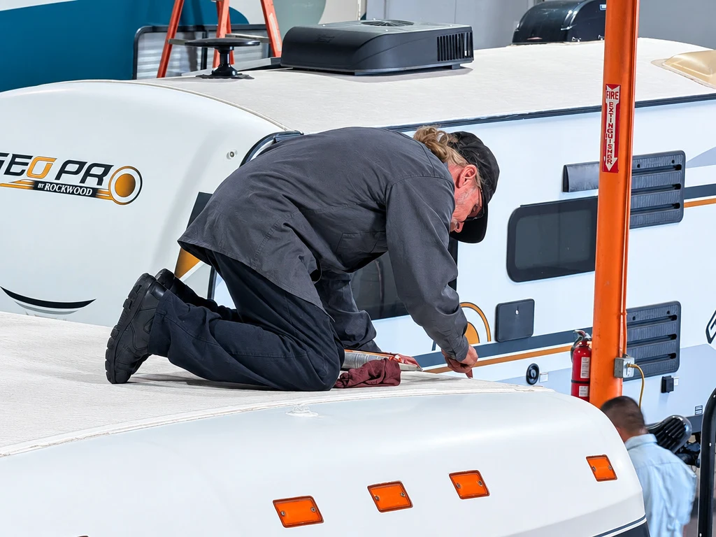 El Toro RV Service technician kneeling on an RV roof during a roof inspection in Orange, CA